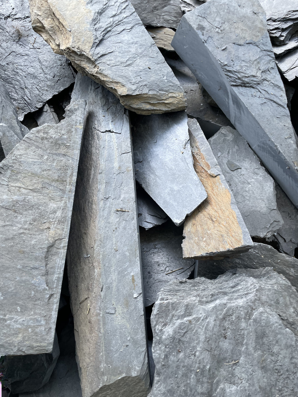 Close-up of large scrap slate pieces in a wheelbarrow