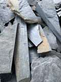 Close-up of large scrap slate pieces in a wheelbarrow