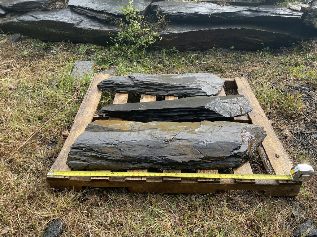 Three dark slate slabs on a pallet ready for freight shipping
